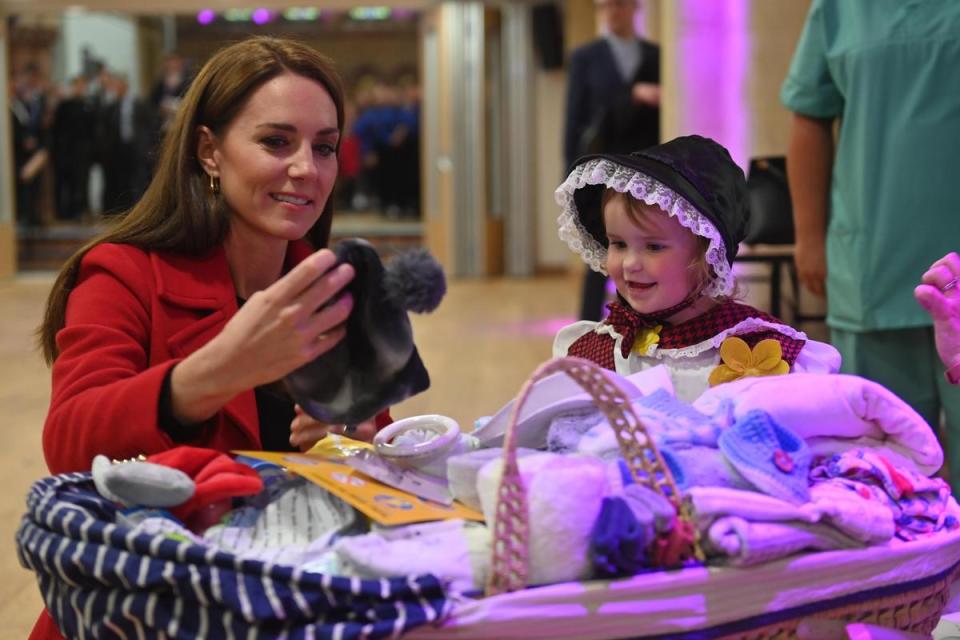 凱特和小女孩在教堂裡，一起整理兒童衣物。（翻攝The Royal Family官網）