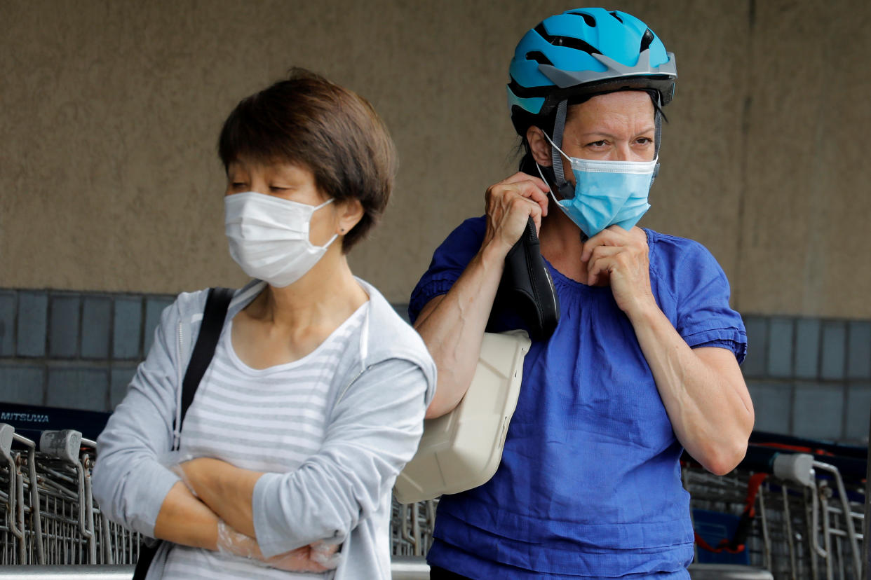 People wear protective face masks outside at a shopping plaza after New Jersey Governor Phil Murphy said he would sign an executive order requiring people to wear face coverings outdoors to prevent a resurgence of the coronavirus disease (COVID-19) in Edgewater, New Jersey, U.S., July 8, 2020. REUTERS/Mike Sega