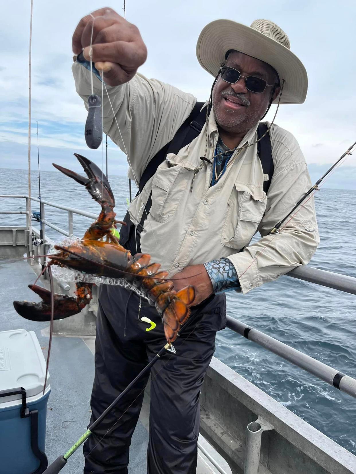 An angler holds up a lobster he caught while fishing on the Paramount party fishing boat on Saturday.