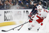 Columbus Blue Jackets' Vladislav Gavrikov, rear, of Russia, and Carolina Hurricanes' Warren Foegele chase the puck during the first period of an NHL hockey game Thursday, Jan. 16, 2020, in Columbus, Ohio. (AP Photo/Jay LaPrete)