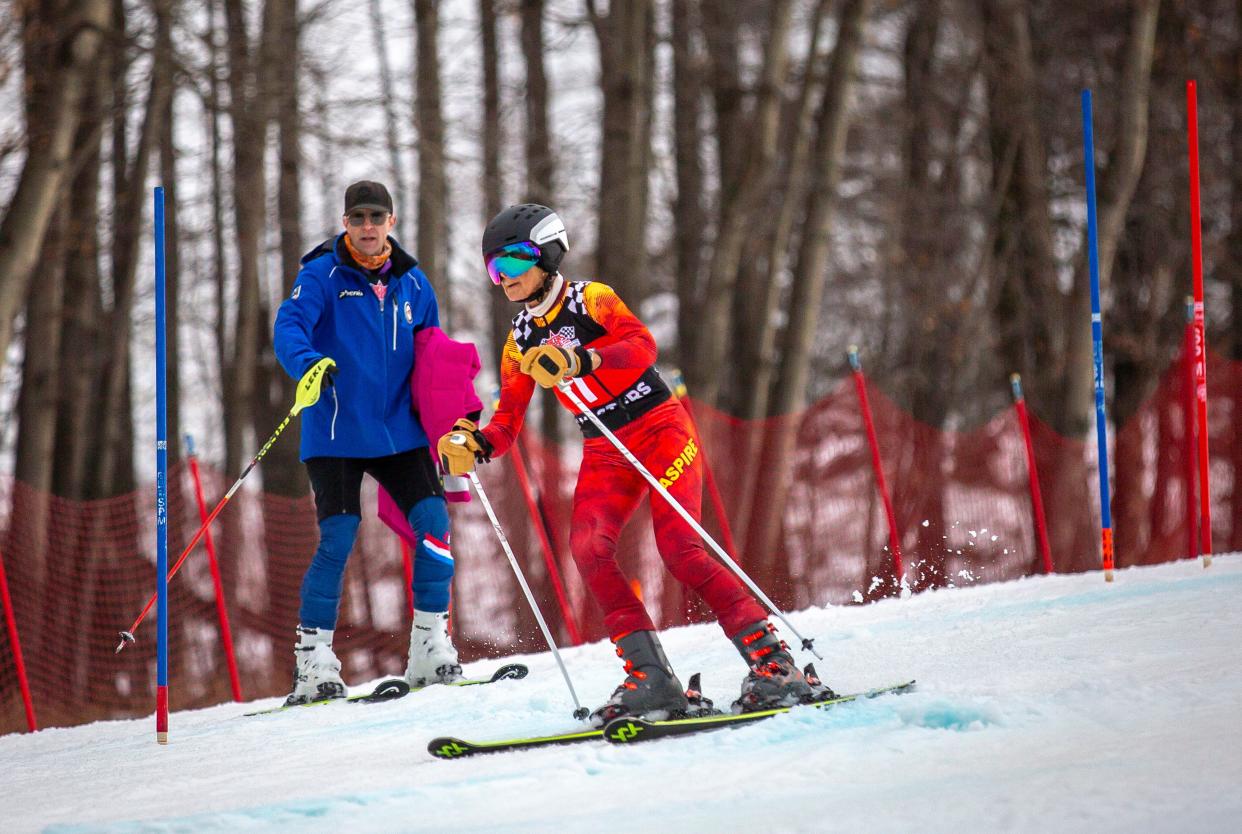 Mary Beth Kuester takes some turns on the slalom course on the Exhibition ski run as Midwest Masters coach Peter Maxwell advises her from the side at Granite Peak Ski Area in Wausau, Wisconsin on Wednesday, February 7, 2024.