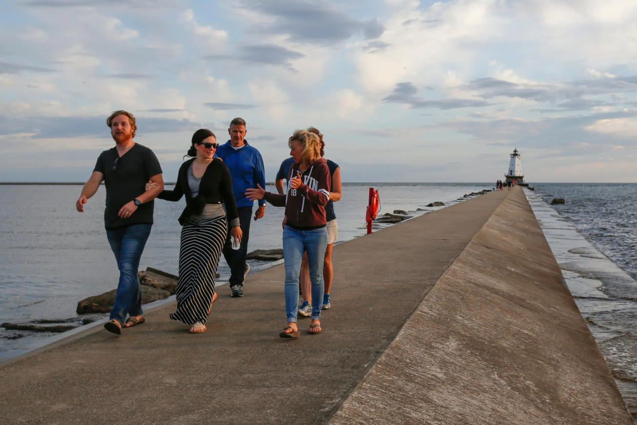 A group of people walk back from the lighthouse June 23, 2017, in Ludington, Michigan.