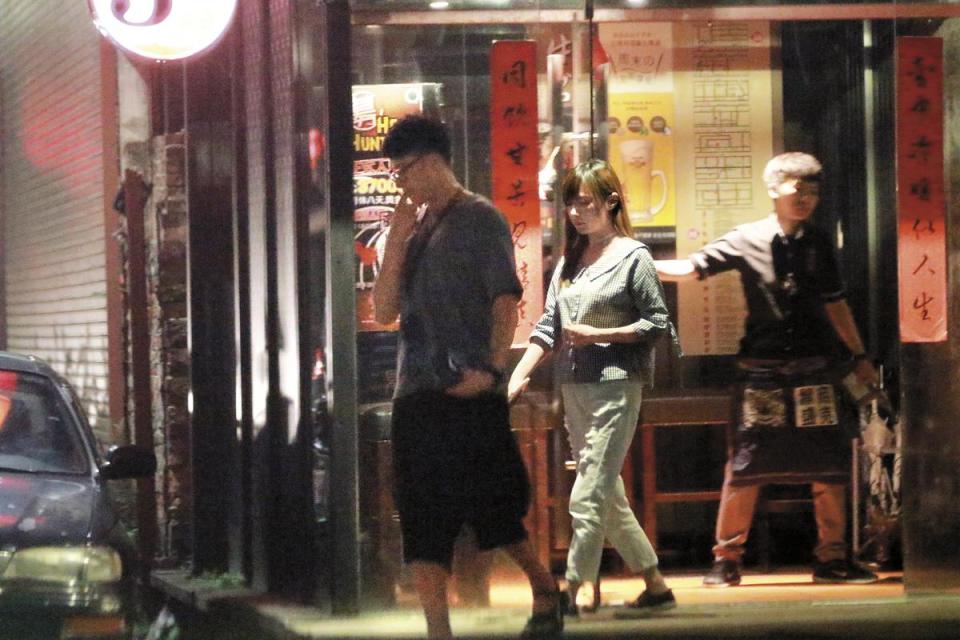8月13日22：56，用完餐後張睿家步出餐廳，女友低頭跟在後面。