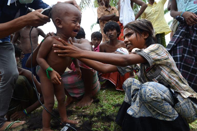 Rohingya children receive haircuts by Indonesian volunteers at the newly set up confinement area for migrants at Bayeun, in Indonesia's Aceh province on May 22, 2015