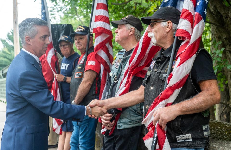 Bucks County Commissioner Board Chair Bob Harvie, left, shakes hands with Ron Delia, right, from Bensalem, alongside other Warriors’ Watch Riders before the dedication and renaming ceremony of Bucks County Bridge no.313 in honor of Warrant Officer William Warren Breece Jr., who was killed in action during the Vietnam War in 1968, in Yardley on Wednesday, Aug. 23, 2023.