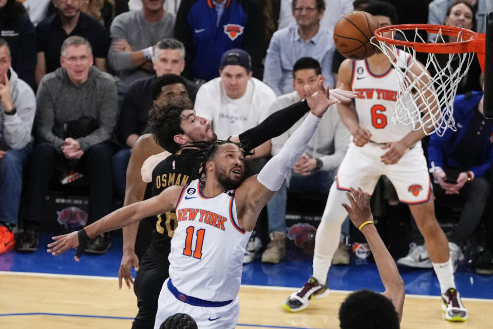 Jalen Brunson (11) dari New York Knicks melewati Cedi Osman dari Cleveland Cavaliers selama paruh pertama Game 3 dalam seri playoff putaran pertama bola basket NBA Jumat, 21 April 2023, di New York.  (Foto AP/Frank Franklin II)