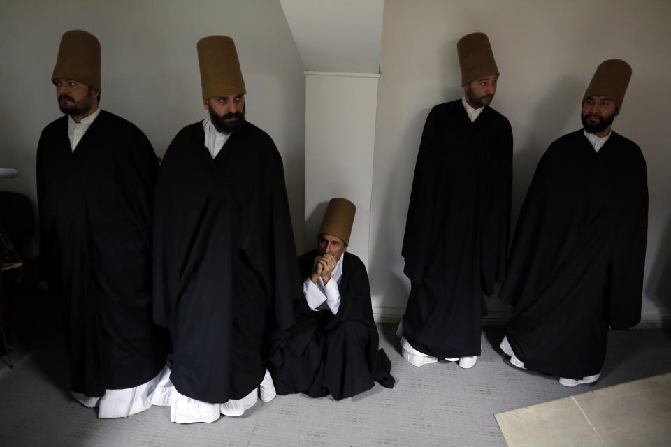 In this photo taken on Sunday, Dec. 16, 2018, whirling dervishes of the Mevlevi order wait to perform at a Sheb-i Arus ceremony in Konya, central Turkey. Every December the Anatolian city hosts a series of events to commemorate the death of 13th century Islamic scholar, poet and Sufi mystic Jalaladdin Rumi. (AP Photo/Lefteris Pitarakis)