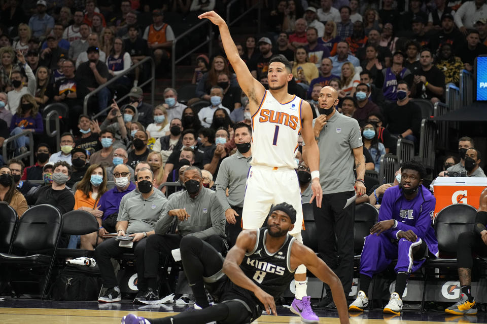 Phoenix Suns guard Devin Booker (1) shoots over Sacramento Kings forward Maurice Harkless during the second half of an NBA basketball game, Wednesday, Oct. 27, 2021, in Phoenix. Sacramento won 110-107. (AP Photo/Rick Scuteri)