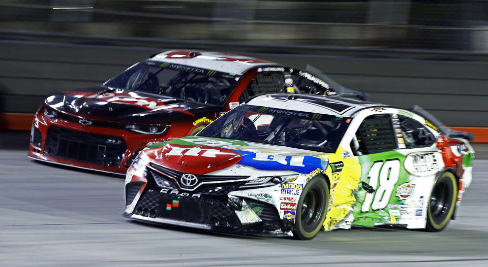 Kyle Busch (18) gets past Austin Dillon during the NASCAR Cup Series auto race, Saturday, Aug. 18, 2018, in Bristol, Tenn. (AP Photo/Wade Payne)