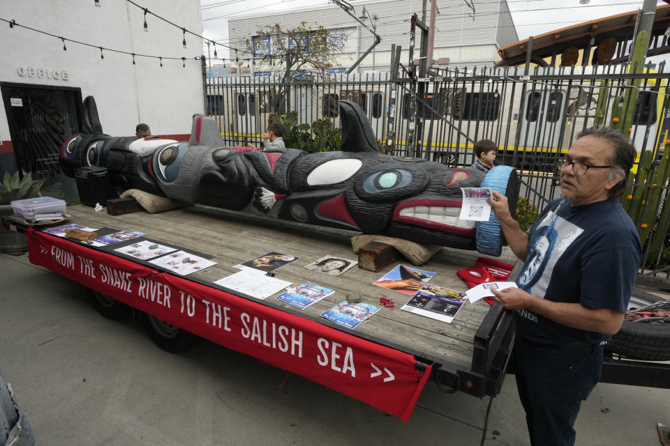 Freddie Lane, a member of the Lummi Nation who traveled from Washington State, with a totem pole touring across the country to stop the degradation of Native lands, joins members of the Apache Stronghold group gathered in the Los Angeles neighborhood of Boyle Heights at Self Help Graphics & Art paint protest signs on Monday, March 20, 2023. The Apache group battling a foreign mining firm that wants to build one of the largest copper mines in the United States on what tribal members say is sacred land will get a new chance to make its point Tuesday when a full federal appeals court panel takes another look at the case. (AP Photo/Damian Dovarganes)