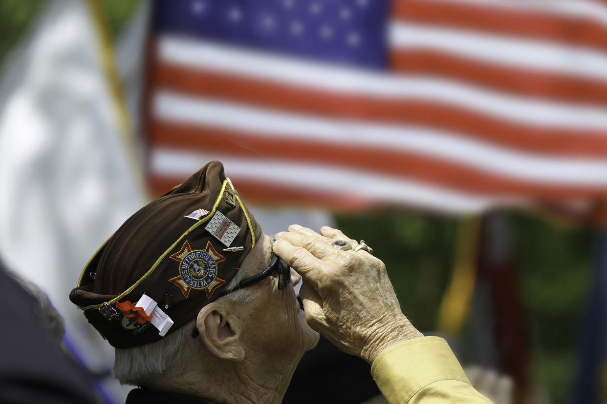 elderly veteran saluting the American flag with the group