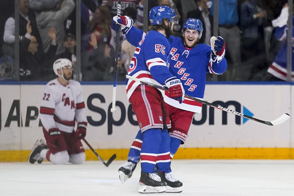 New York Rangers defenseman Adam Fox, right, celebrates with defenseman Ryan Lindgren (55) after scoring on Carolina Hurricanes goaltender Antti Raanta in the first period of Game 4 of an NHL hockey Stanley Cup second-round playoff series, Tuesday, May 24, 2022, in New York. (AP Photo/John Minchillo)