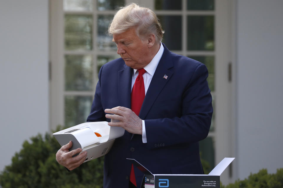 President Donald Trump opens a box containing a 5-minute test for COVID-19 from Abbott Laboratories on March 30.  (Photo: ASSOCIATED PRESS)