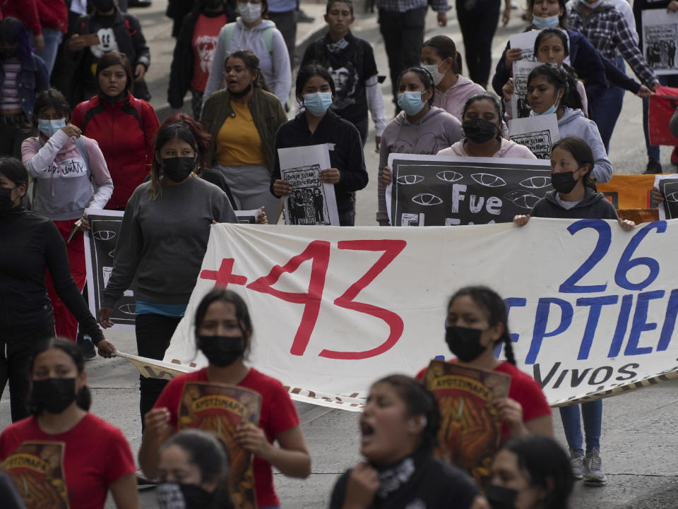 Relatives and classmates of the missing 43 Ayotzinapa college students and supporters march in Mexico City, Monday, Sept. 26, 2022, on the day of the anniversary of the disappearance of the students in Iguala, Guerrero state. Three members of the military and a former federal attorney general were recently arrested in the case, and few now believe the government's initial claim that a local drug gang and allied local officials were wholly to blame for seizing and killing the students on July 26, 2014, most of which have never been found. (AP Photo/Marco Ugarte)