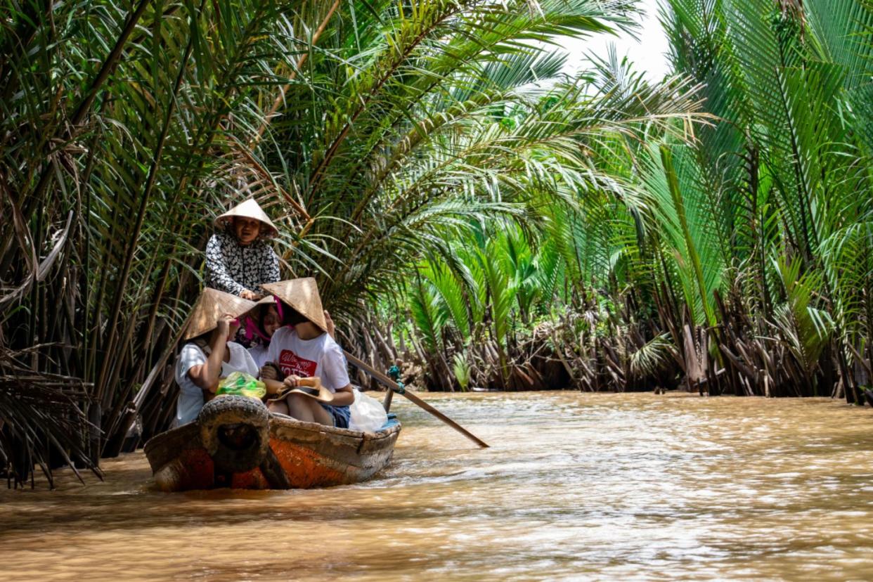 people in a boat floating down river in Vietnam