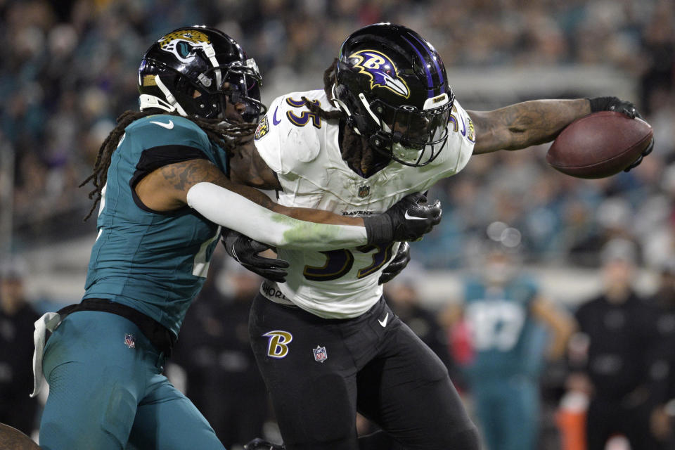 Baltimore Ravens running back Gus Edwards (35) tries to get past Jacksonville Jaguars safety Rayshawn Jenkins in the second half of an NFL football game Sunday, Dec. 17, 2023, in Jacksonville, Fla.(AP Photo/Phelan M. Ebenhack)