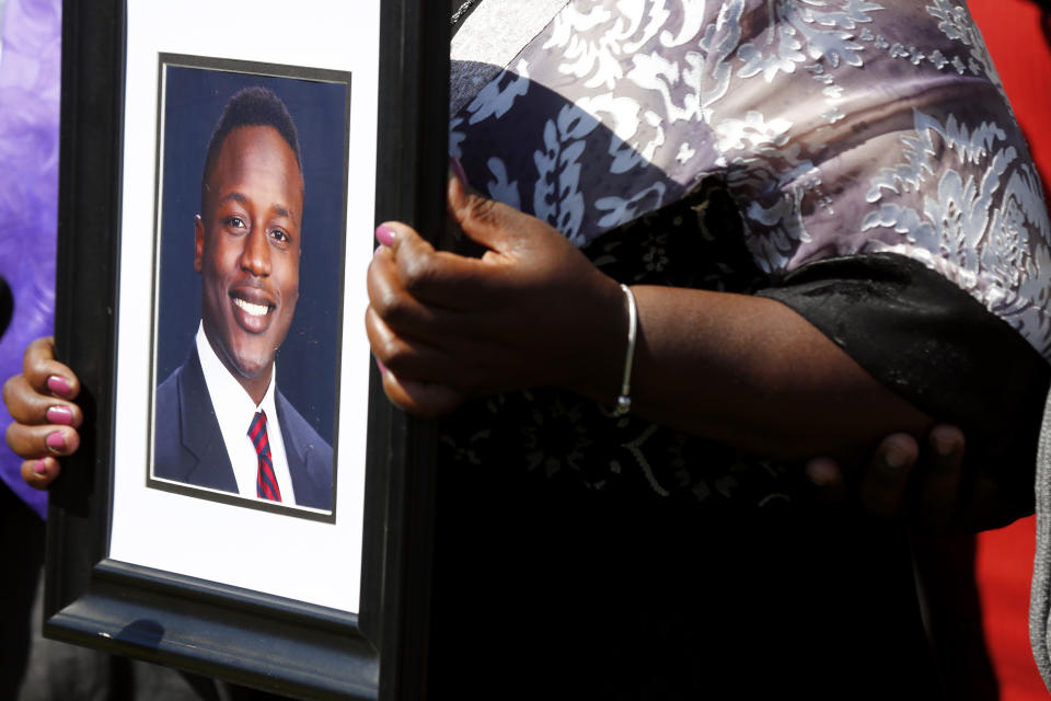 FILE - Caroline Ouko, mother of Irvo Otieno, holds a portrait of her son at the Dinwiddie Courthouse in Dinwiddie, Va., March 16, 2023. On Sunday, May 5, 2024, a Virginia judge signed off on a prosecutor's request to withdraw charges against five more people in connection with the 2023 death of Otieno, a young man who was pinned to the floor for about 11 minutes while being admitted to a state psychiatric hospital. (Daniel Sangjib Min/Richmond Times-Dispatch via AP, File)