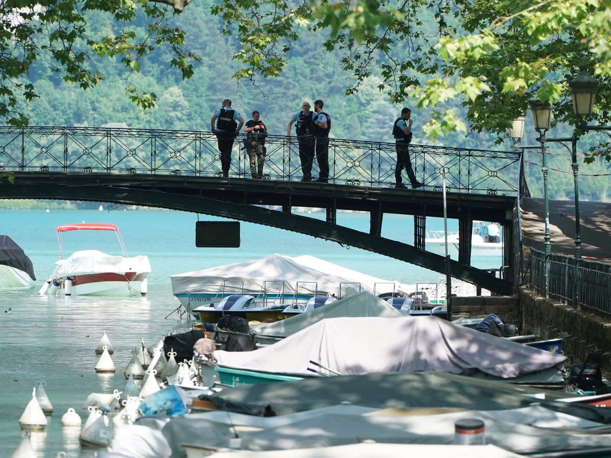 Police on a bridge near the scene in Annecy (AP)