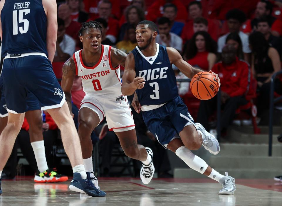 Rice Owls guard Travis Evee, right, dribbles the ball as Houston Cougars guard Marcus Sasser defends during the first half of a Nov. 12, 2021, game in Houston at Fertitta Center.