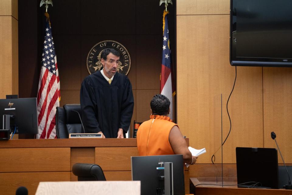 Fulton County Superior Court Judge Robert McBurney receives documents from County Court Clerk Che Alexander