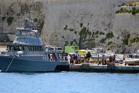 Migrants disembark from a Maltese Patrol boat after they were transferred from the rescue vessel Alan kurdi, at the maritime base in Pieta