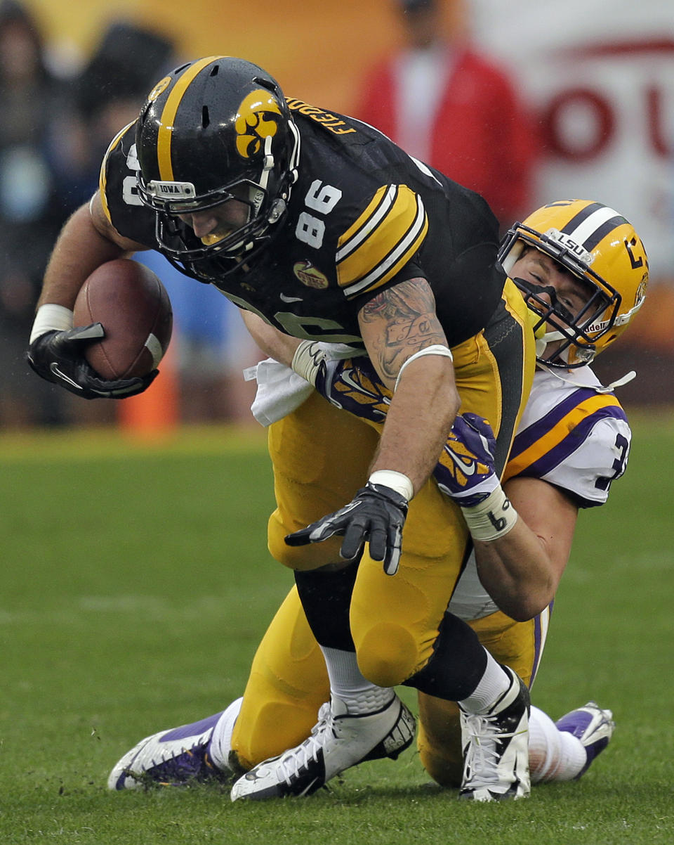 Iowa tight end C.J. Fiedorowicz (86) is stopped by LSU linebacker D.J. Welter (32) after a reception during the first quarter of the Outback Bowl NCAA college football game Wednesday, Jan. 1, 2014, in Tampa, Fla. (AP Photo/Chris O'Meara)