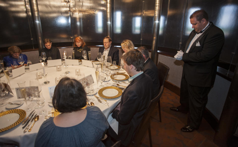 Maitre de Ryan Roberts leads guests in a moment of silence for the 1514 people who died when the RMS Titanic sank during a re-creation of the final first class dinner served on the ship, Saturday, April 14, 2012, in Houston. The Titanic sank in the North Atlantic Ocean April 15, 1912 after colliding with an iceberg during her maiden voyage from Southampton, England to New York. (AP Photo/Dave Einsel)