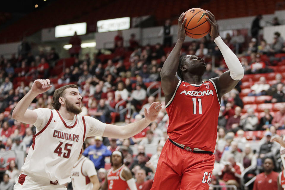 Arizona center Oumar Ballo (11) drives to the basket next to Washington State forward Oscar Cluff (45) during the first half of an NCAA college basketball game, Saturday, Jan. 13, 2024, in Pullman, Wash. (AP Photo/Young Kwak)