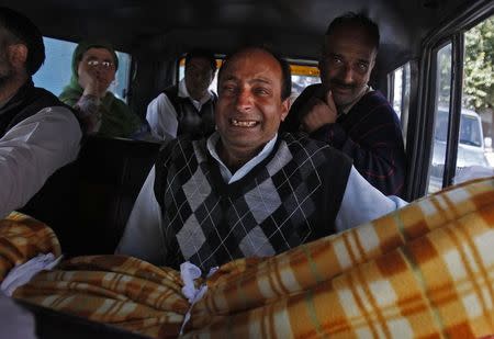 A man cries as he carries the body of his father, a flood casualty in Srinagar September 14, 2014. REUTERS/Danish Ismail