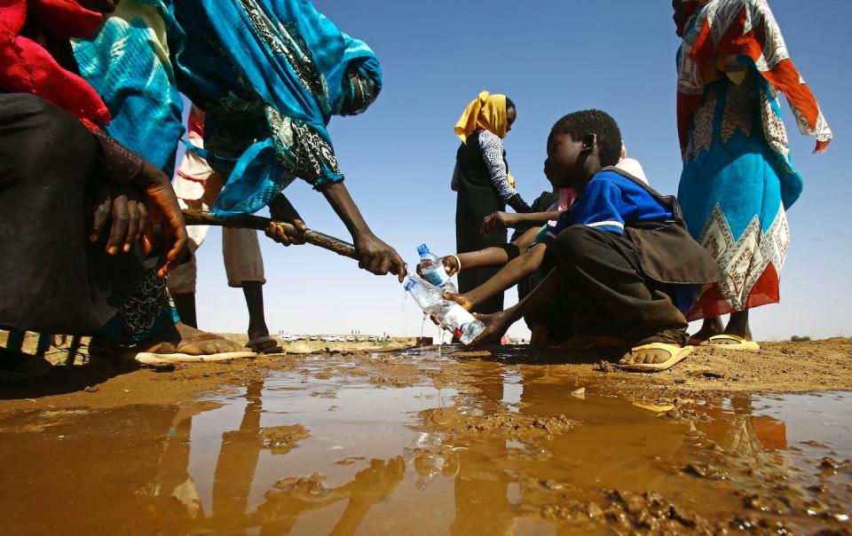 A woman in Sudan fills a water bottle for a child during the 2017 drought. <a href="https://www.gettyimages.com/detail/news-photo/sudanese-woman-fills-water-bottles-held-by-a-young-boy-news-photo/634410354" rel="nofollow noopener" target="_blank" data-ylk="slk:Ashraf Shazly/AFP via Getty Images;elm:context_link;itc:0;sec:content-canvas" class="link ">Ashraf Shazly/AFP via Getty Images</a>