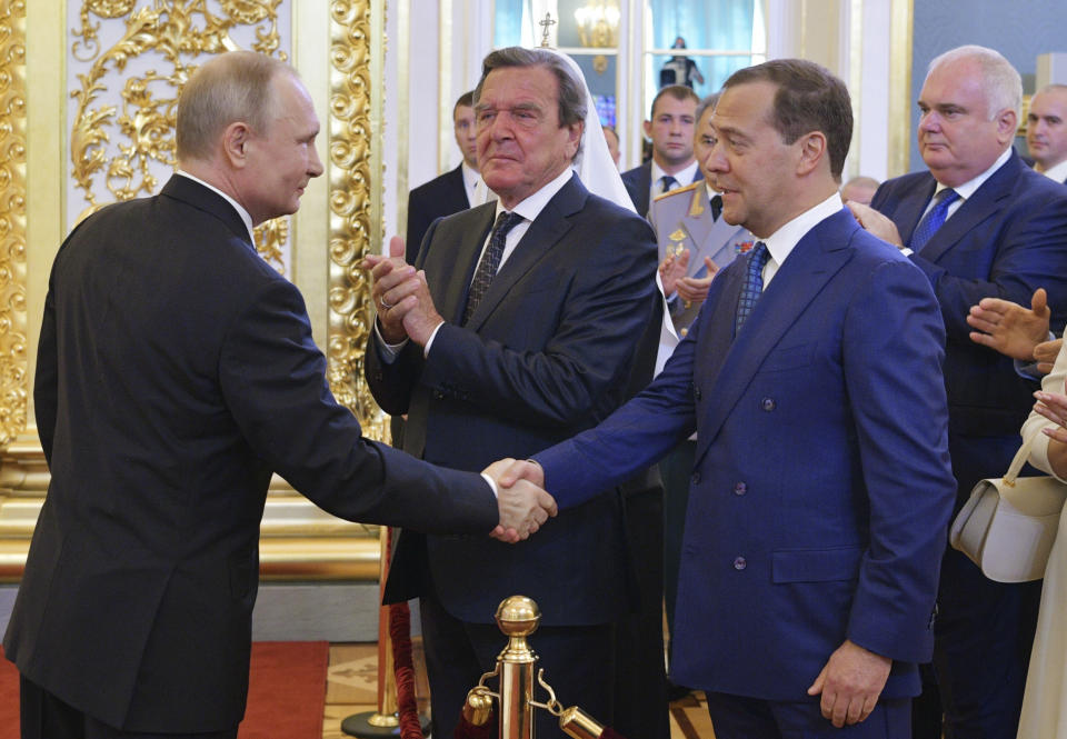 FILE - Vladimir Putin shakes hands with Dmitry Medvedev during his inauguration ceremony as new Russia's president in the Grand Kremlin Palace in Moscow, Russia, on May 7, 2018, with former German Chancellor Gerhard Schroeder in centre. Gerhard Schroeder left the German chancellery after a narrow election defeat in 2005 with an ambitious overhaul of the country’s welfare state beginning to kick in and every chance of becoming a respected elder statesman. Fast-forward to last week: German lawmakers agreed to shut down Schroeder’s taxpayer-funded office, the European Parliament called for him to be sanctioned, and his own party set a mid-June hearing on applications to have him expelled. Schroeder’s association with the Russian energy sector turned the 78-year-old into a political pariah in Germany after the invasion of Ukraine. (Alexei Druzhinin, Sputnik, Kremlin Pool Photo via AP)