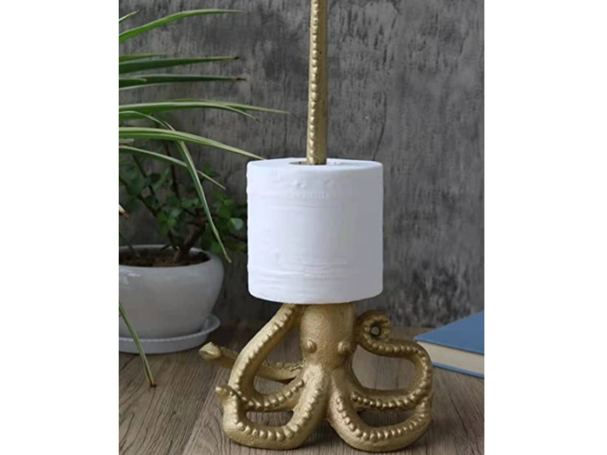 Gold octopus statue with long tentacle holding toilet paper roll