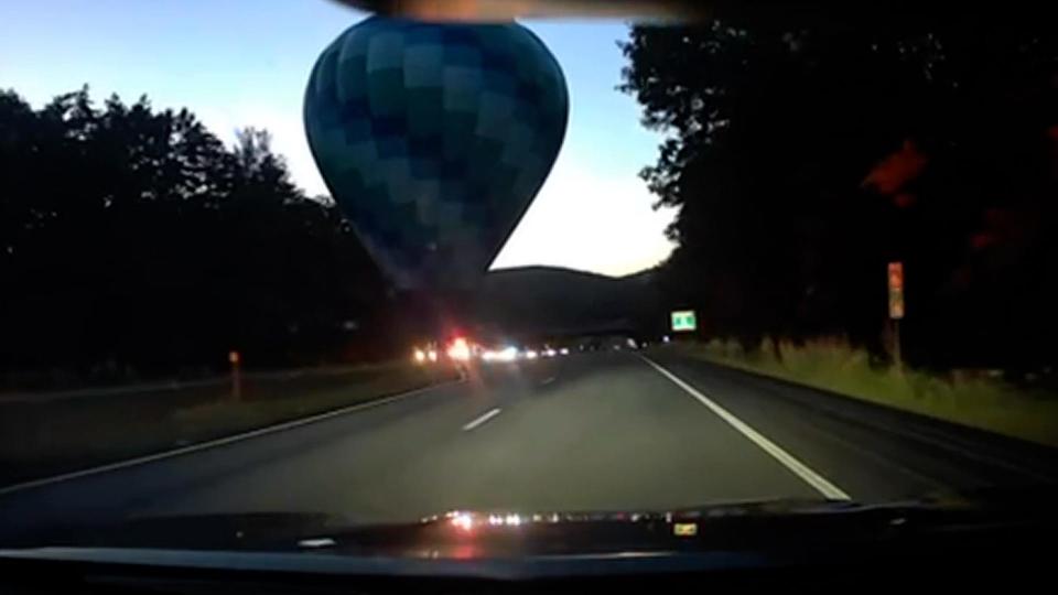 A still image of a video shows a hot air balloon that was forced to land on a highway in Vermont after a mid-flight issue with the wind.