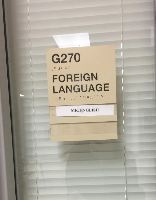 Sign on a door reading "G270 FOREIGN LANGUAGE" with "MR. ENGLISH" below in Braille and text