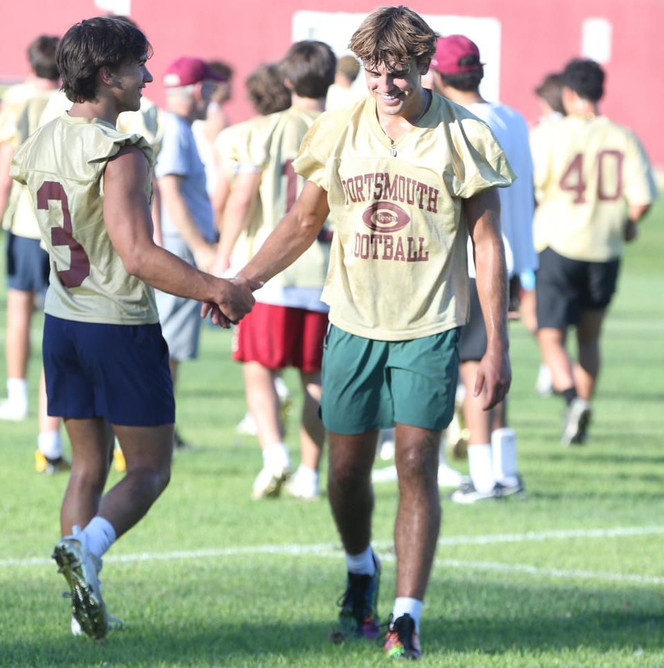 Portsmouth/Oyster River football players Dom Buono and Cole McLaughlin high-five each other at the end of the first day of practice for the 2023 fall season at Portsmouth High School on Friday, Aug. 11.