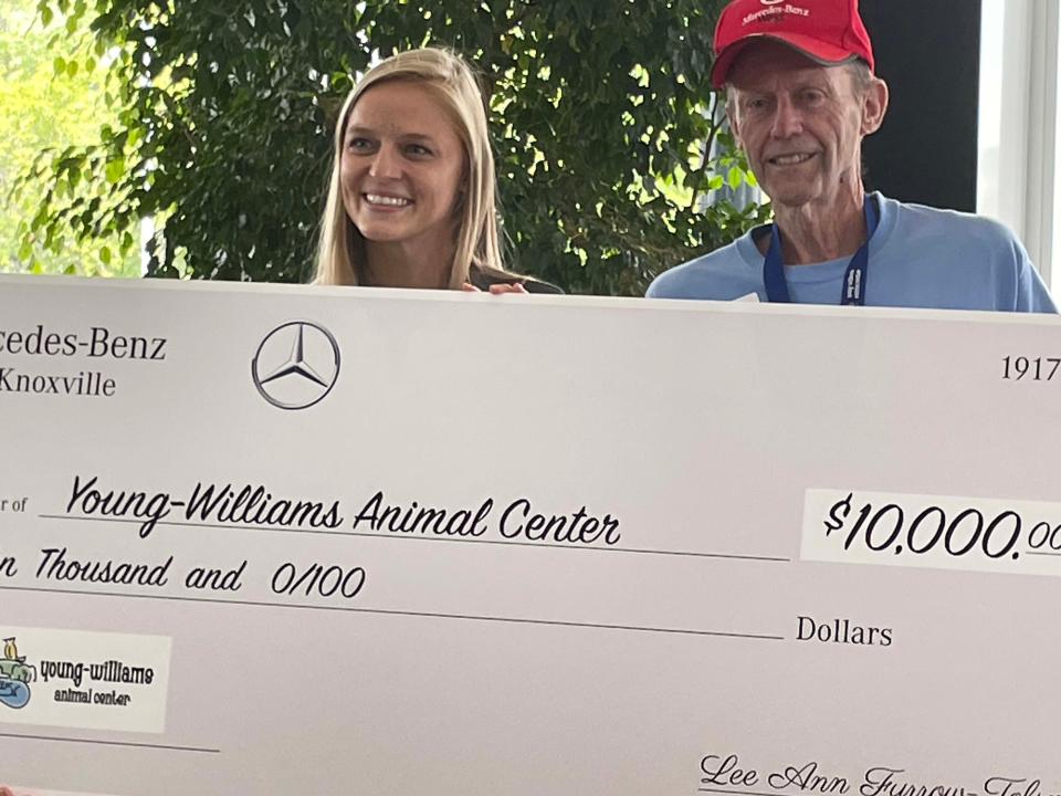 Grace Bennett, associate director of development for Young-Williams Animal Center, and volunteer Ray Wagner receive $10,000 from the Furrow Automotive Group’s Mercedes-Benz of Knoxville at a presentation held at the dealership Thursday, July 21, 2022.
