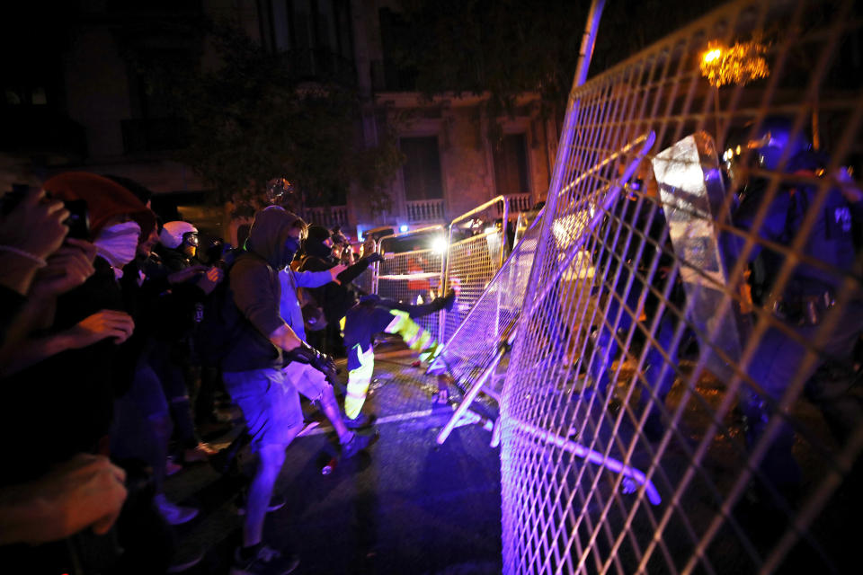 Protestors kick down a fence outside the Spanish Government Office in Barcelona, Spain, Tuesday, Oct. 15, 2019. Spain's Supreme Court on Monday convicted 12 former Catalan politicians and activists for their roles in a secession bid in 2017, a ruling that immediately inflamed independence supporters in the wealthy northeastern region. (AP Photo/Emilio Morenatti)