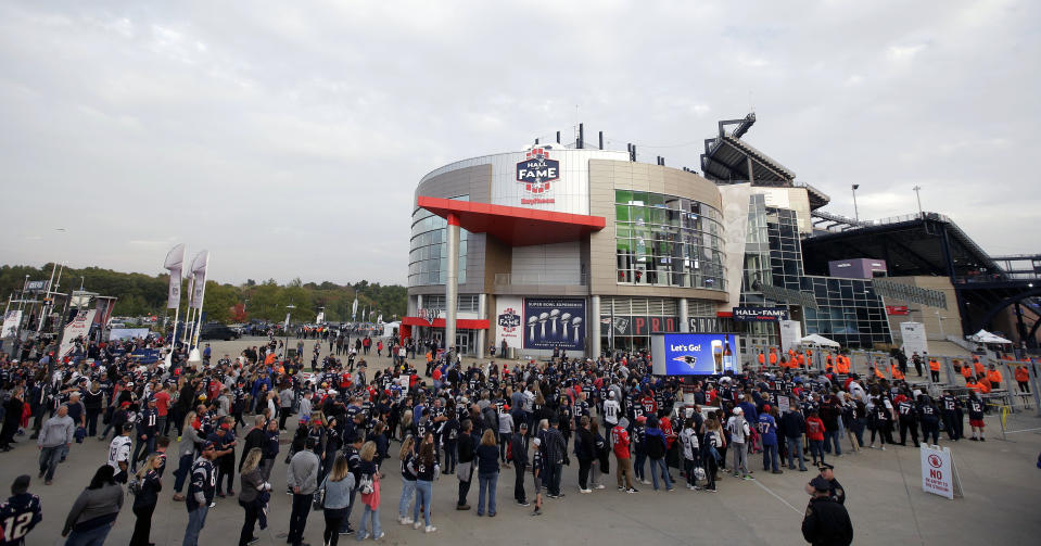 FILE - In this Oct. 4, 2018, file photo, fans line up to enter Gillette Stadium for an NFL football game between the New England Patriots and the Indianapolis Colts, in Foxborough, Mass. The crippling coronavirus pandemic has brought the entire world — including the sports world — to a standstill, and it shows no sign of going away anytime soon. The most obvious change in the short term will be the implementation of social distancing, something that already has permeated everyday life. Ticket sales will be capped and fans will be given an entrance time to prevent crowds at the gate. (AP Photo/Steven Senne, File)