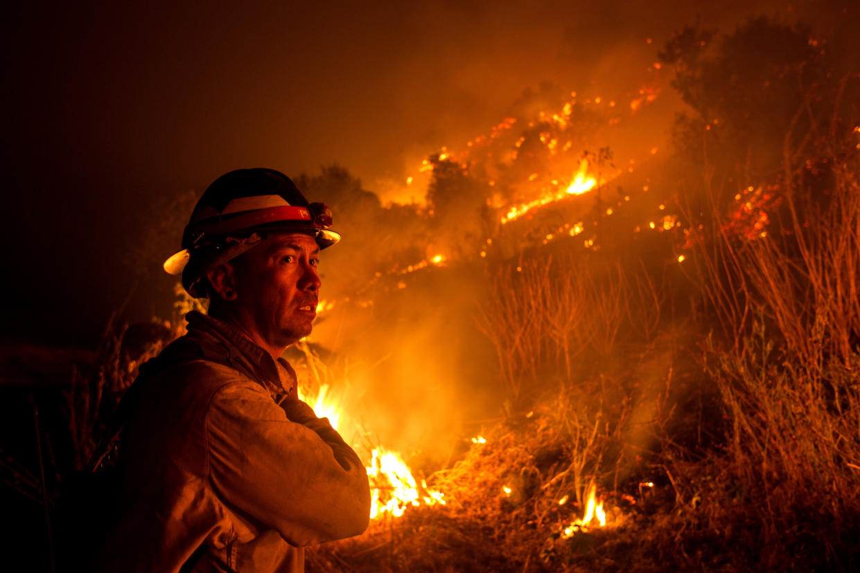 A firefighter watches the Bobcat Fire burning on hillsides near Monrovia Canyon Park in Monrovia, California on September 15, 2020. - A major fire that has been raging outside Los Angeles for more than a week threatened to engulf a historic observatory and billion-dollar broadcast towers on September 15 as firefighters struggled to contain the flames. The so-called Bobcat Fire was within 500 feet (150 meters) from the 116-year-old Mt. Wilson Observatory, the US Forest Service said in a tweet, while fire officials said crews were in place "ready to receive the fire." (Photo by RINGO CHIU / AFP) (Photo by RINGO CHIU/AFP via Getty Images)