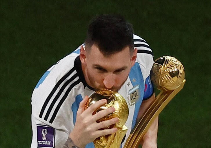 Foto del domingo del capitan de Argentina Lionel Messi besando la Copa del Mundo tras recibir el Balón de Oro