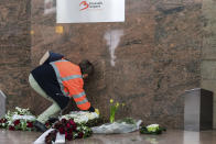 A Brussels Airport workers lays flowers at a memorial, marking the one-year anniversary at Zaventem Airport in Brussels on Wednesday, March 22, 2017. The suicide bombings at the Brussels airport and subway on March 22, 2016, killed 32 people and wounded more than 300 others. (AP Photo/Geert Vanden Wijngaert)