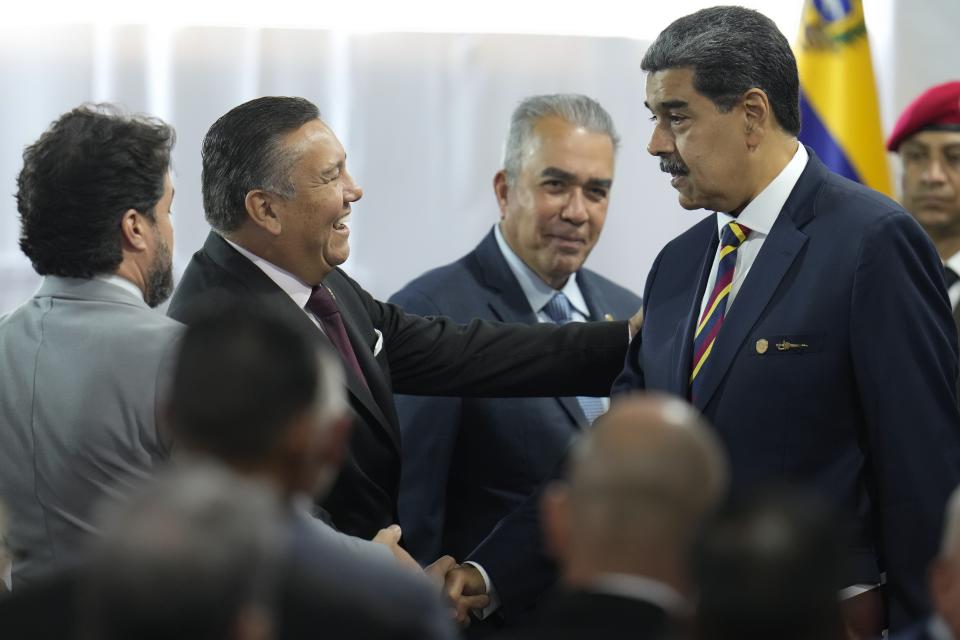 Venezuelan President Nicolas Maduro, right, shakes hands with presidential candidate Javier Bertucci after a signing agreement ceremony to respect the results of the upcoming presidential elections, at the National Electoral Council headquarters in Caracas, Venezuela, Thursday, June 20, 2024. (AP Photo/Ariana Cubillos)