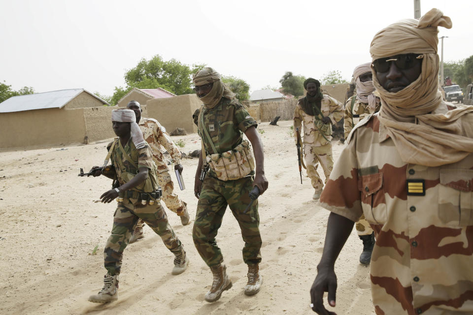 Chadian soldiers escorting a group of journalists walk in the city of Damasak, Nigeria, Wednesday March 18, 2015. (AP Photo/Jerome Delay)