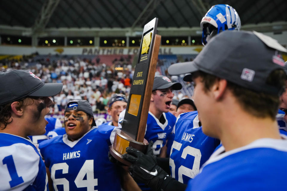 Remsen St. Mary's team celebrate with the trophy after winning the eight-man playoff finals Thursday, Nov. 17, 2022, at the UNI-Dome in Cedar Falls. The Hawks defeated the Warriors, 38-16.