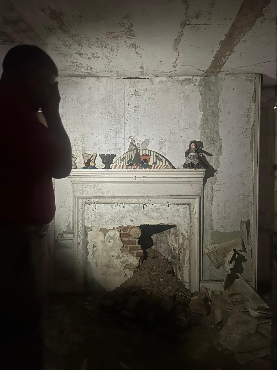 Dr. Walt Quint shines the flashlight from his phone into a room at the Samuel Paul House in Paulsboro.