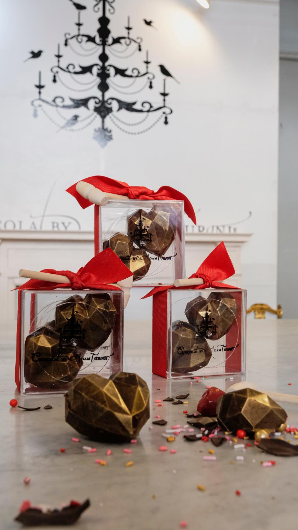 These dark chocolate hearts come dusted with gold and with a small wooden mallet to bust them open like piñatas with even more sweet treats for lovers to share... or for the broken-hearted to smash and indulge.