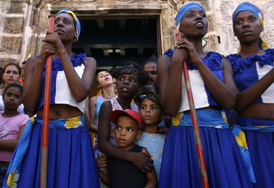 Dancers in colorful costumes perform in a street in Havana, a tradition established in colonial times that gave slaves one day a year to freely celebrate in the streets with dance and drums.