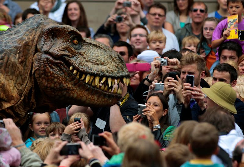 FILE PHOTO: Visitors photograph an animatronic Tyrannosaurus rex at the reopening of the National Museum of Scotland after its three-year ¬£47 million redevelopment in Edinburgh