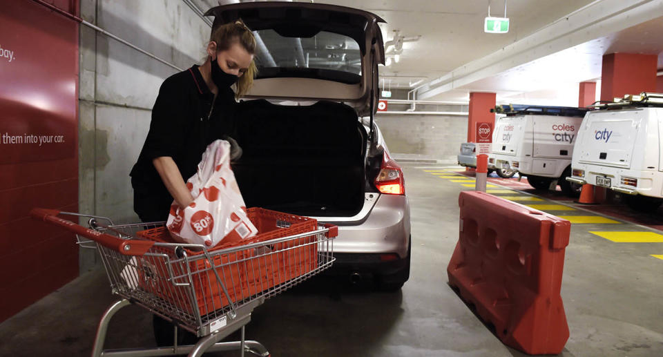 A woman loading a Coles Click and Collect order into a car. Source: Getty Images