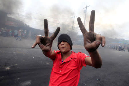 A supporter of Salvador Nasralla, presidential candidate for the Opposition Alliance Against the Dictatorship, gestures while standing at a barricade settled to block road during a protest caused by the delayed vote count for the presidential election in Tegucigalpa, Honduras December 1, 2017. REUTERS/Jorge Cabrera